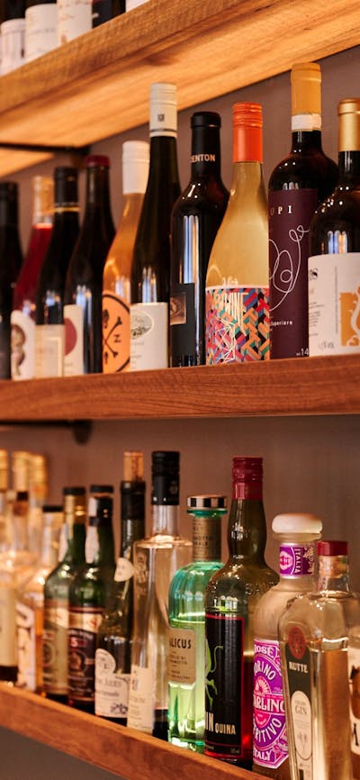 Wall shelf close up full of wine bottles