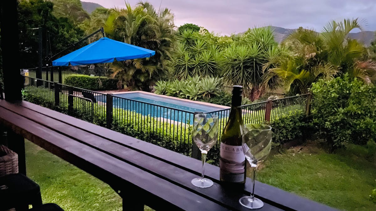 Brumbies Hollow cabin verandah featuring two wine glasses over looking the pool