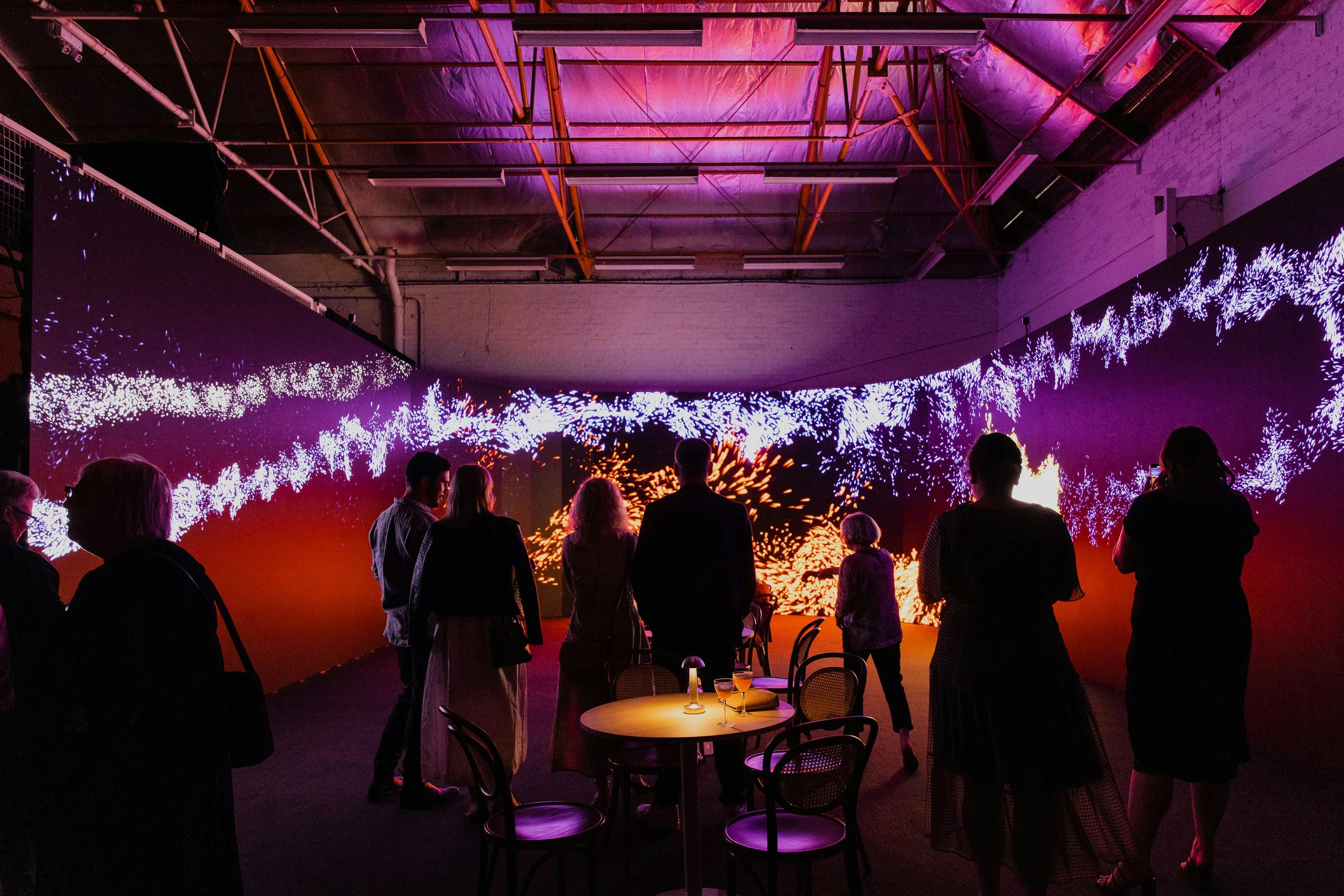 A group of people using the interactive immersive experience surrounded by LED screens