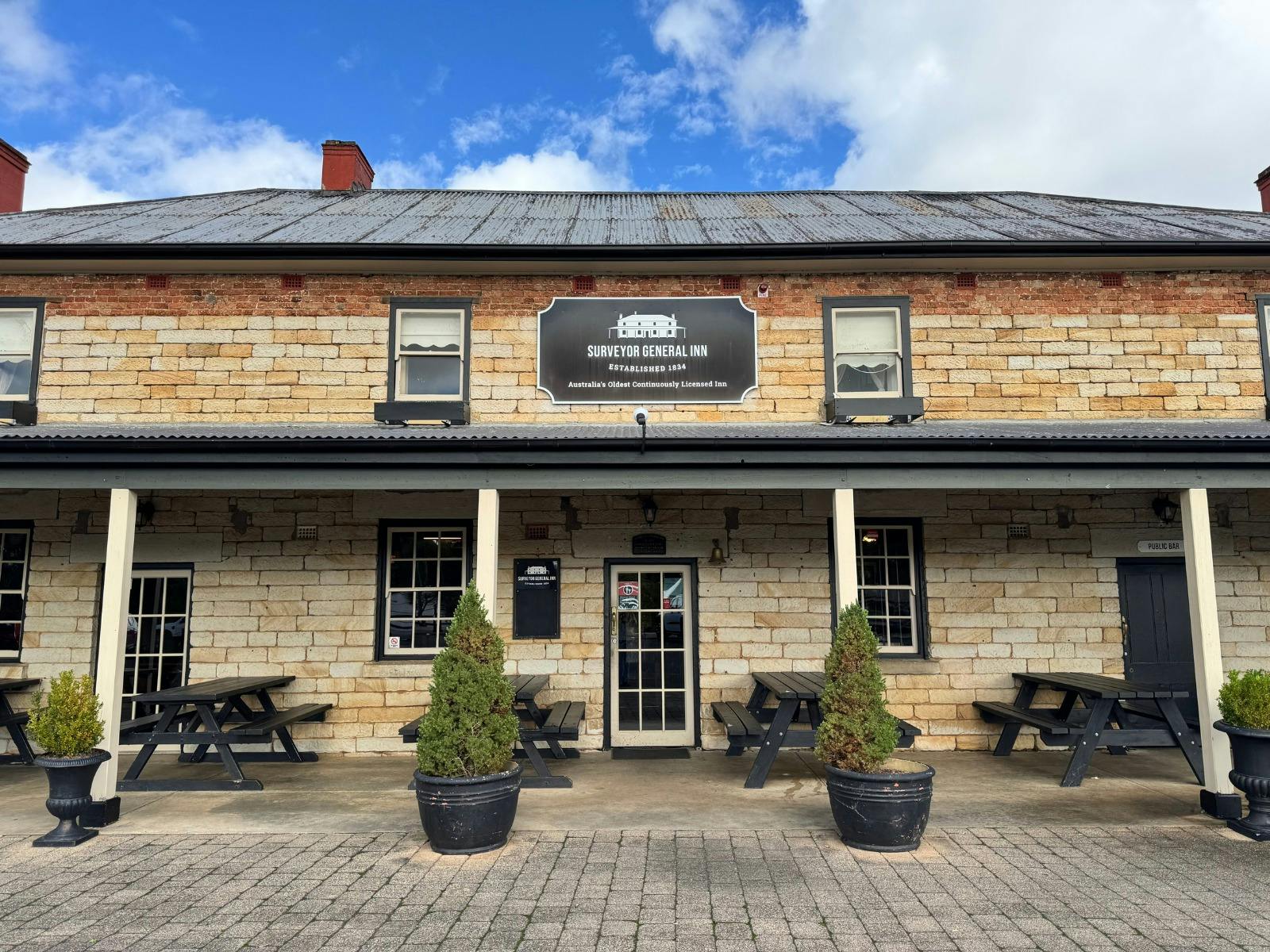 A convict-built sandstone inn fills the frame.