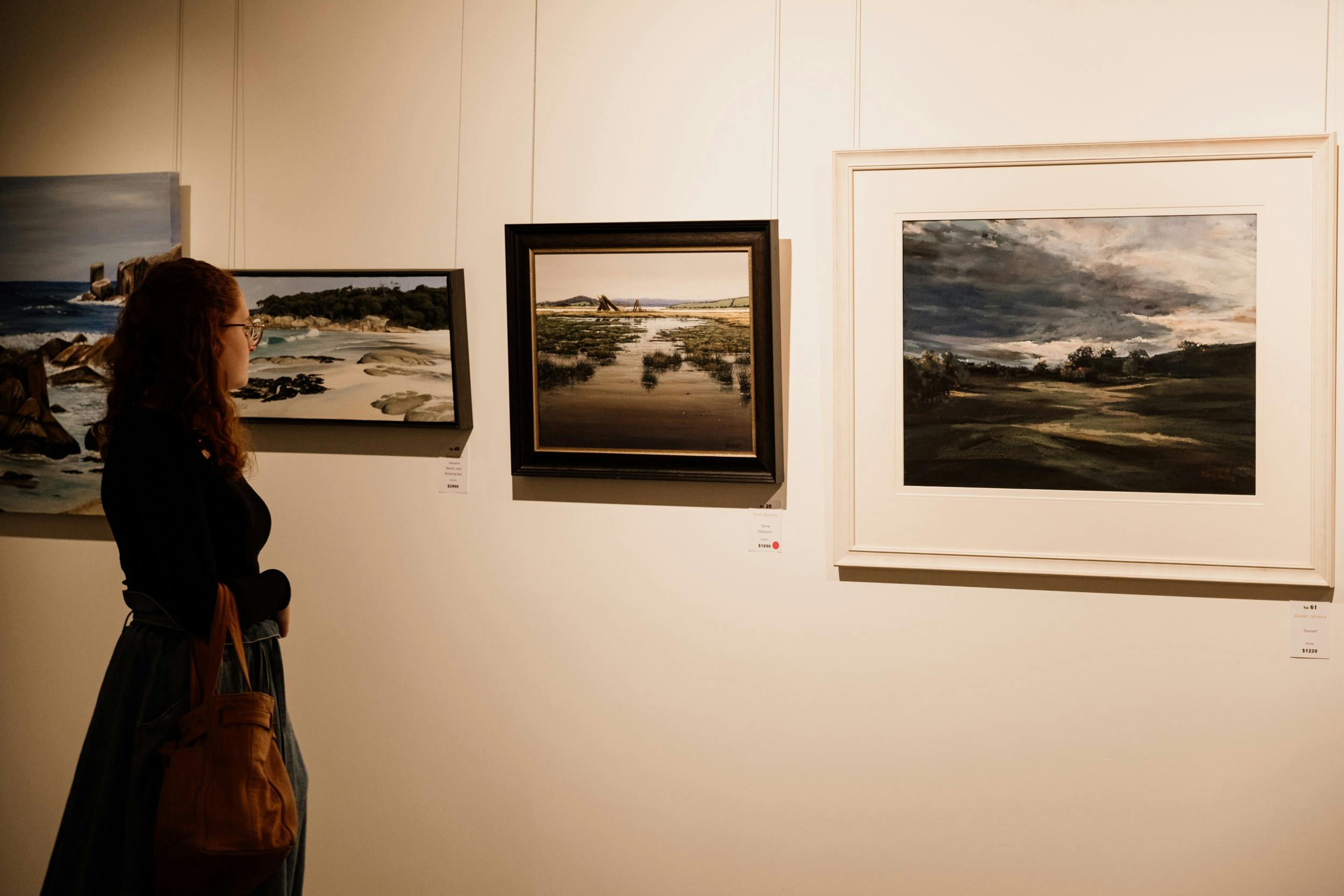 Person standing in front of art in gallery