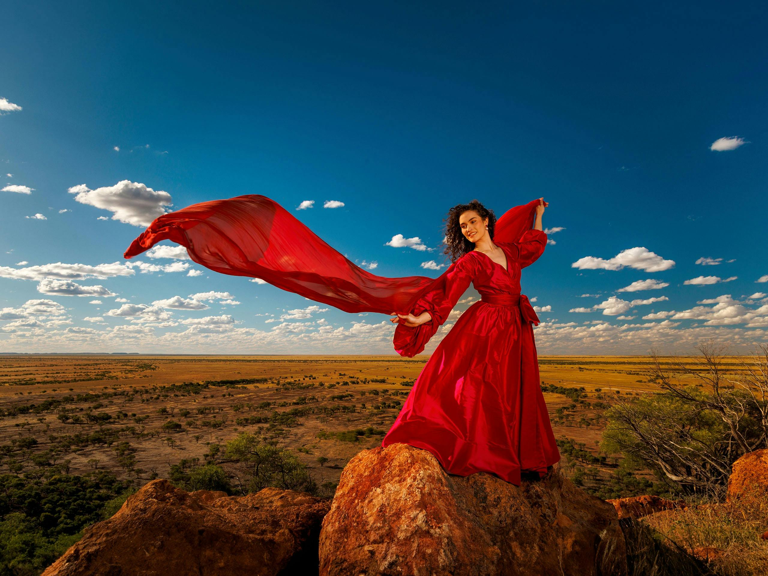 Girl in Red Ballgown with the outback plains behind her