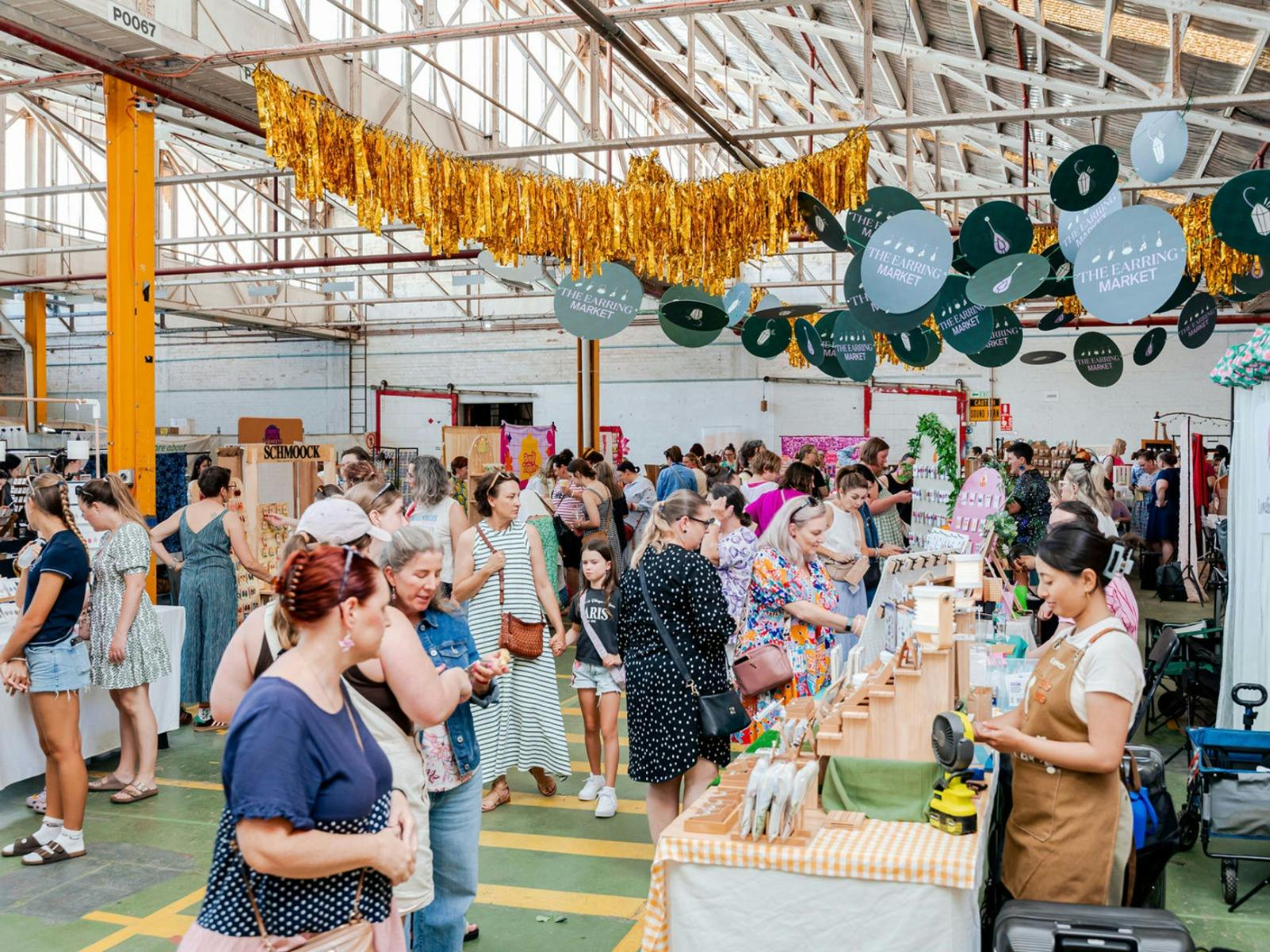 A group shot of the crowds and stalls at the earring market from the corner of the room