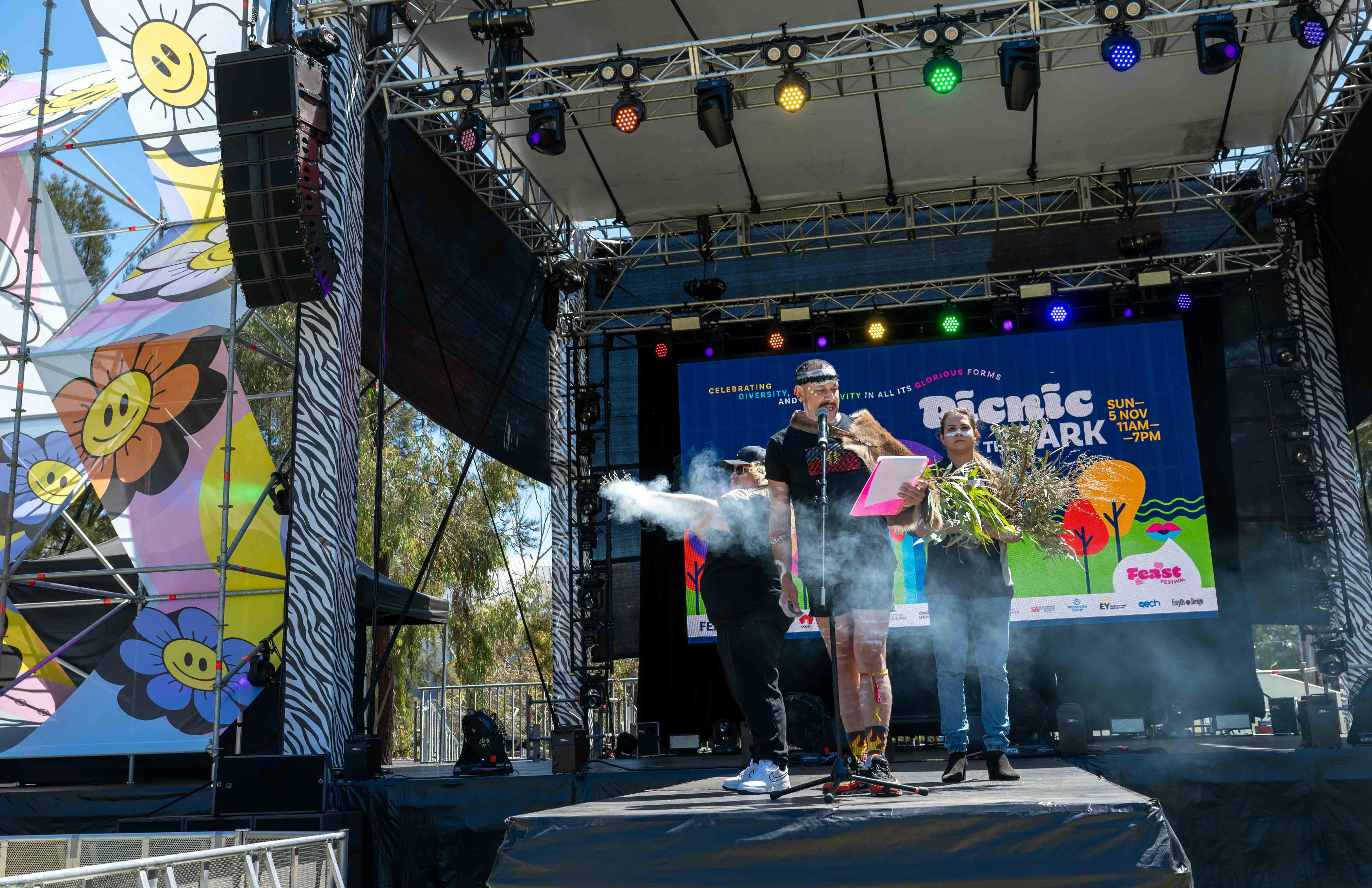 Three people on stage at the Picnic in the Park event.