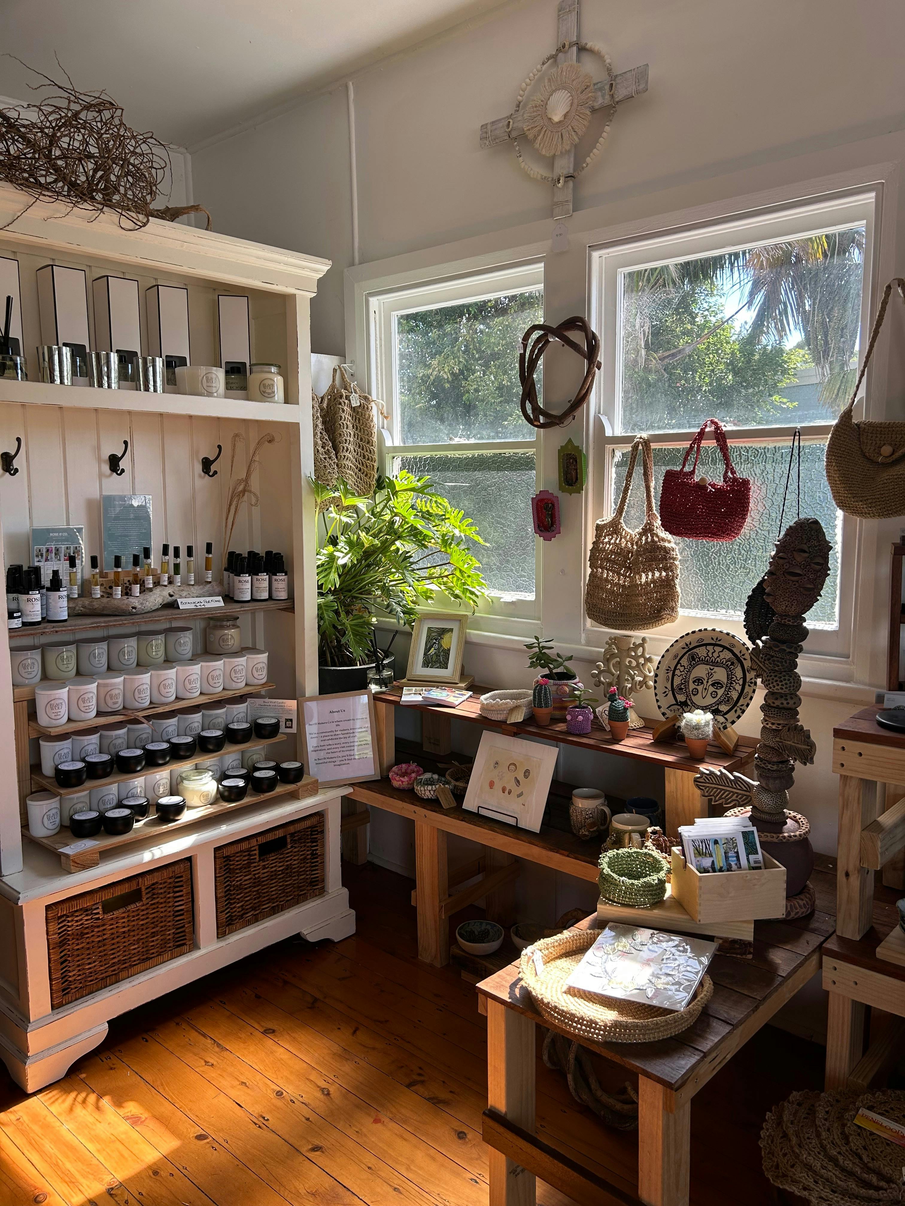 Multiple displays of makers creations including candles, botanical perfume and skin care, woven art