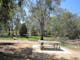 Picnic table, share cycling and walking track, trees, grass, wetland is distance
