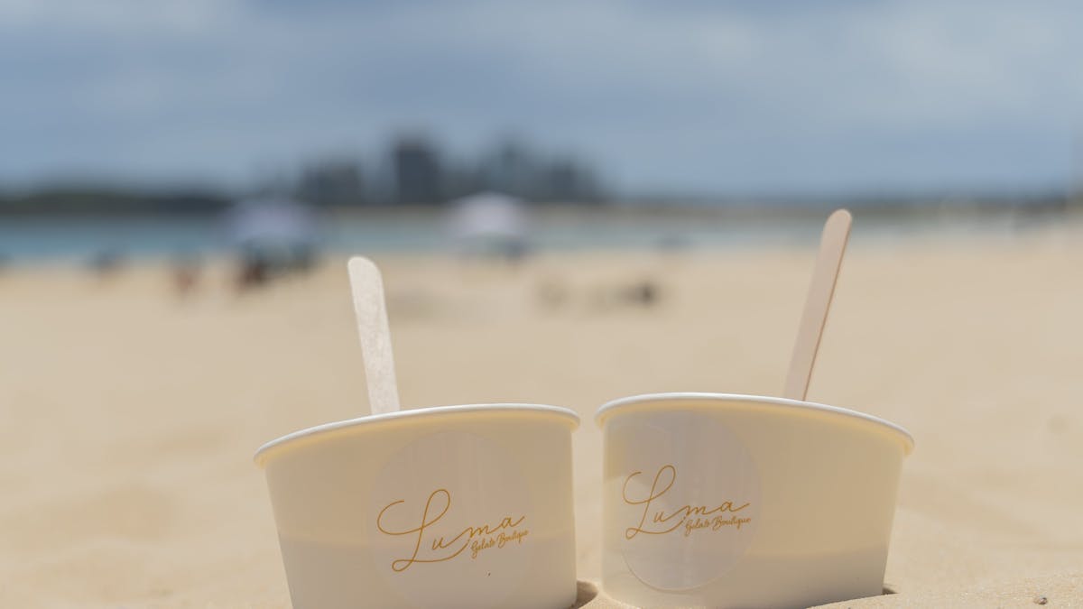 Two LUMA Gelato cups on the sand at Mooloolaba Beach