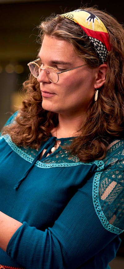 Tour attendee handling a small ceramic object with latext gloves on