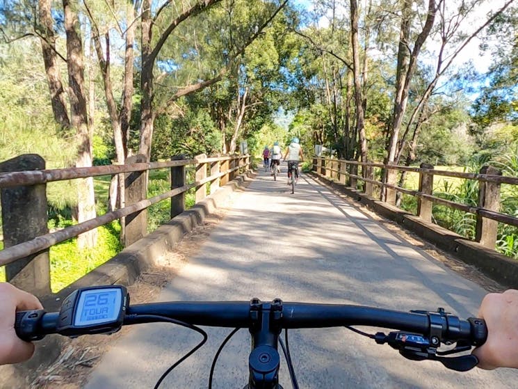 Crossing a bridge in The Pocket on a Guided E Bike tour to Hells Hole Pools in the Byron Hinterland