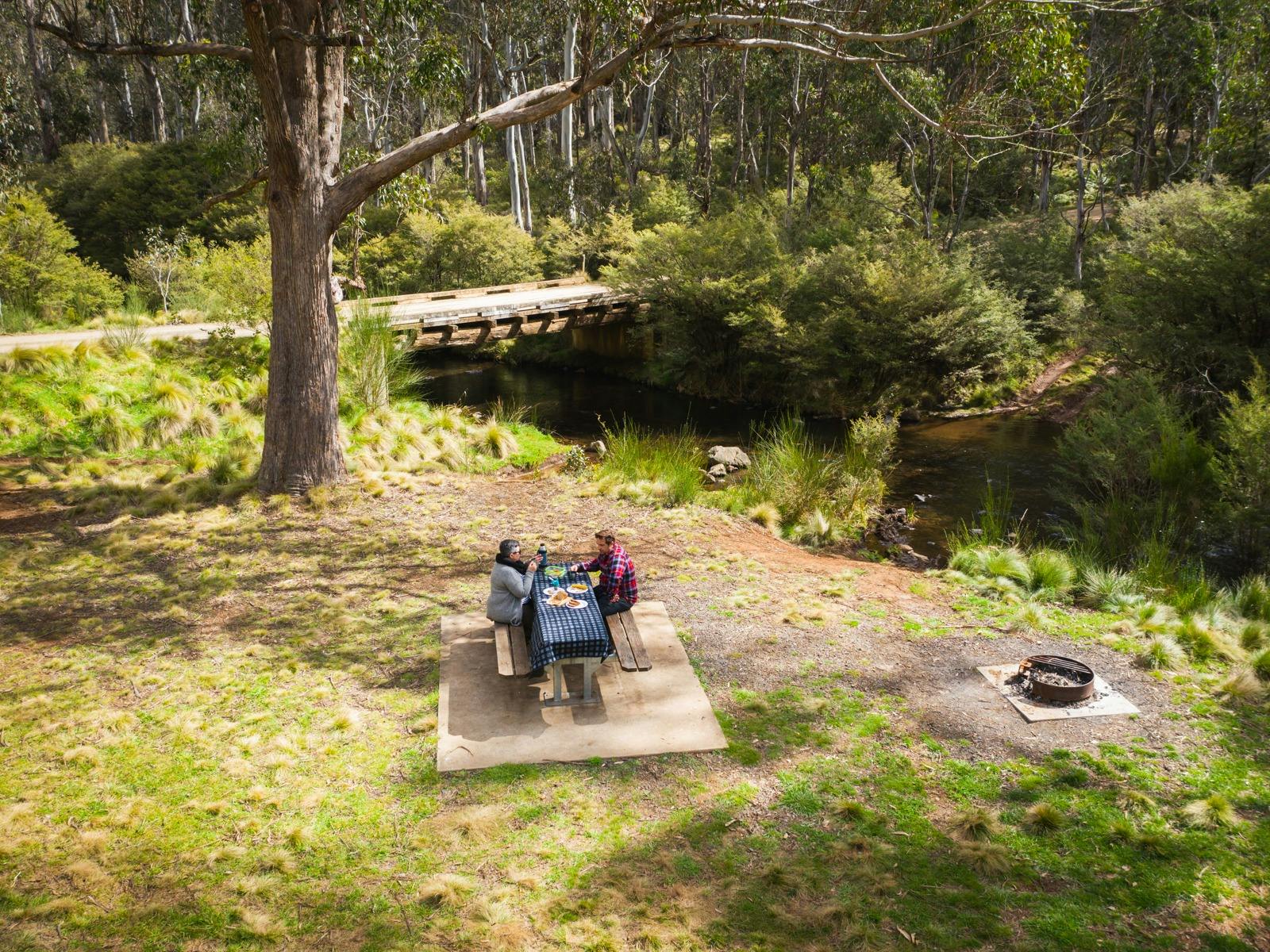 A couple enjoys a picnic on the banks of the Manning River, Barrington Tops State Forest