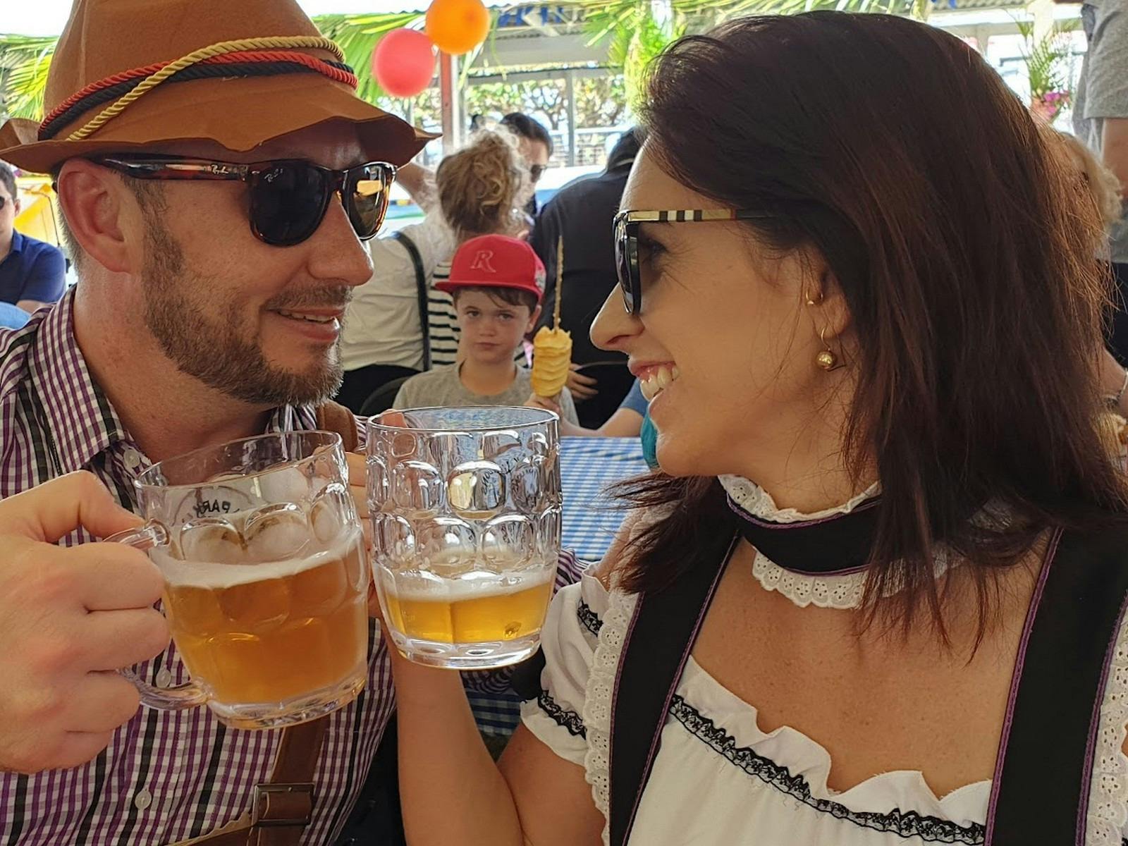 A boy and a girl clinking beer glasses.