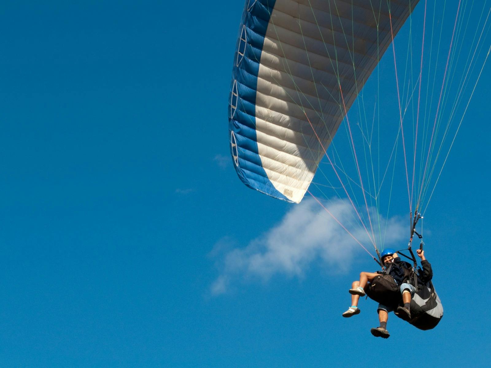Tandem paragliding flight with blue sky