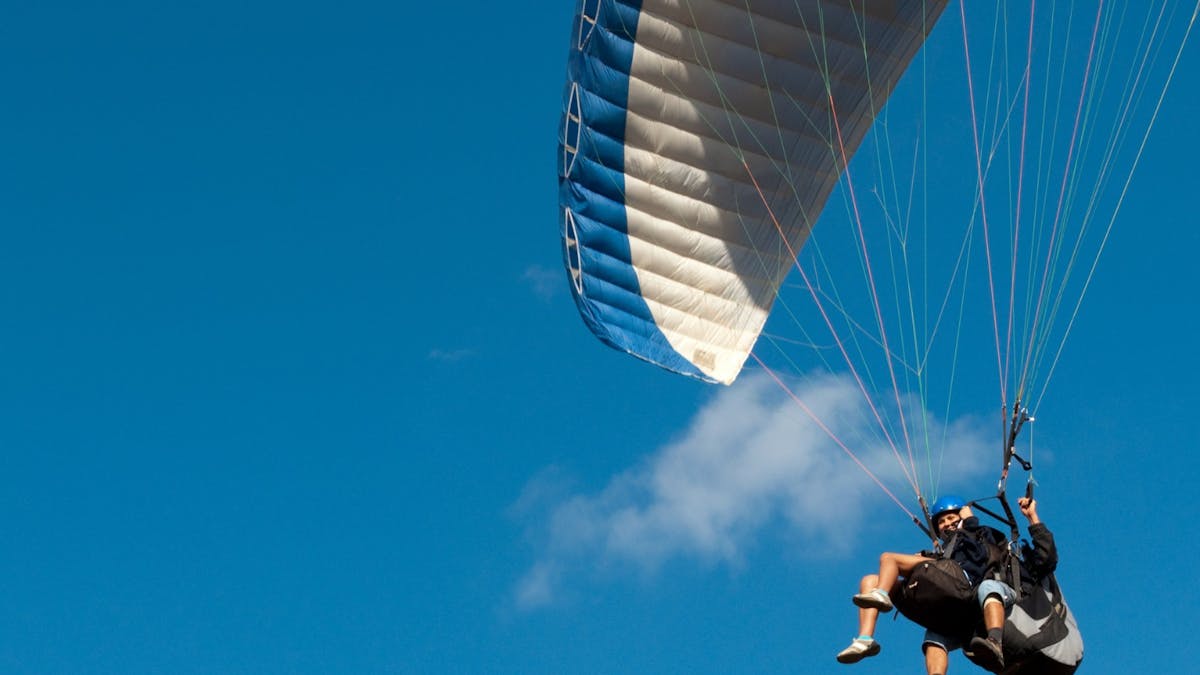 Tandem paragliding flight with blue sky