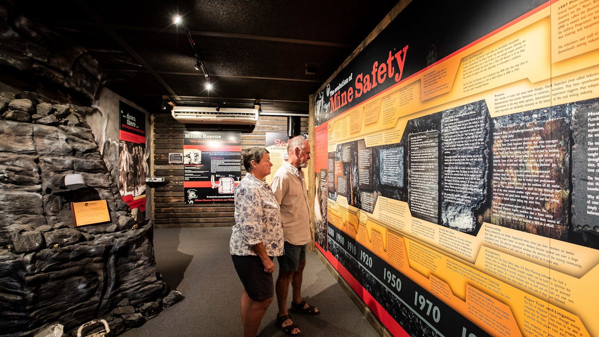 Lady and man looking at mine safety information  display inside the museum