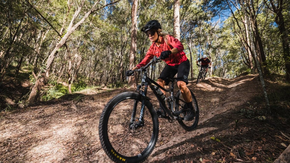 Couple riding mountain bikes and enjoying trails at Redlands Track Park, QLD.