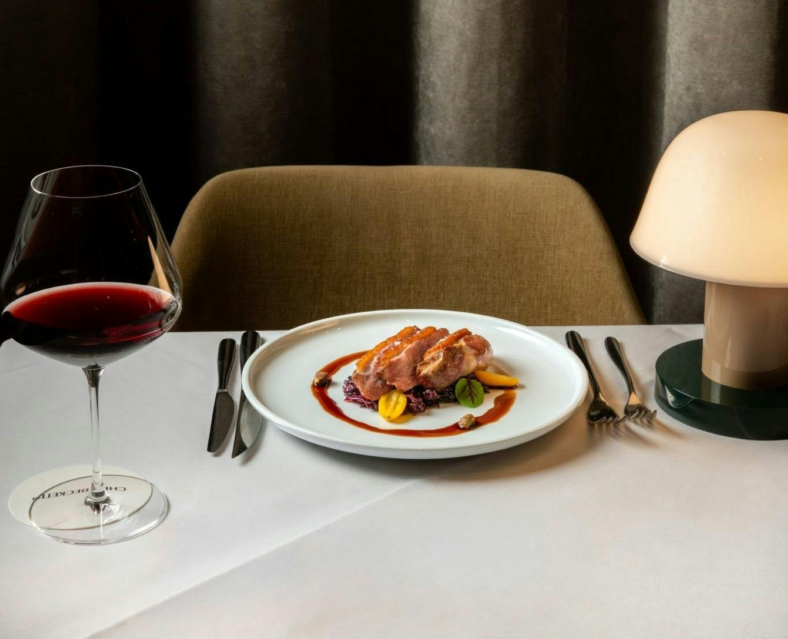 food on a table with red wine and lamp at Beckett’s Chippendale