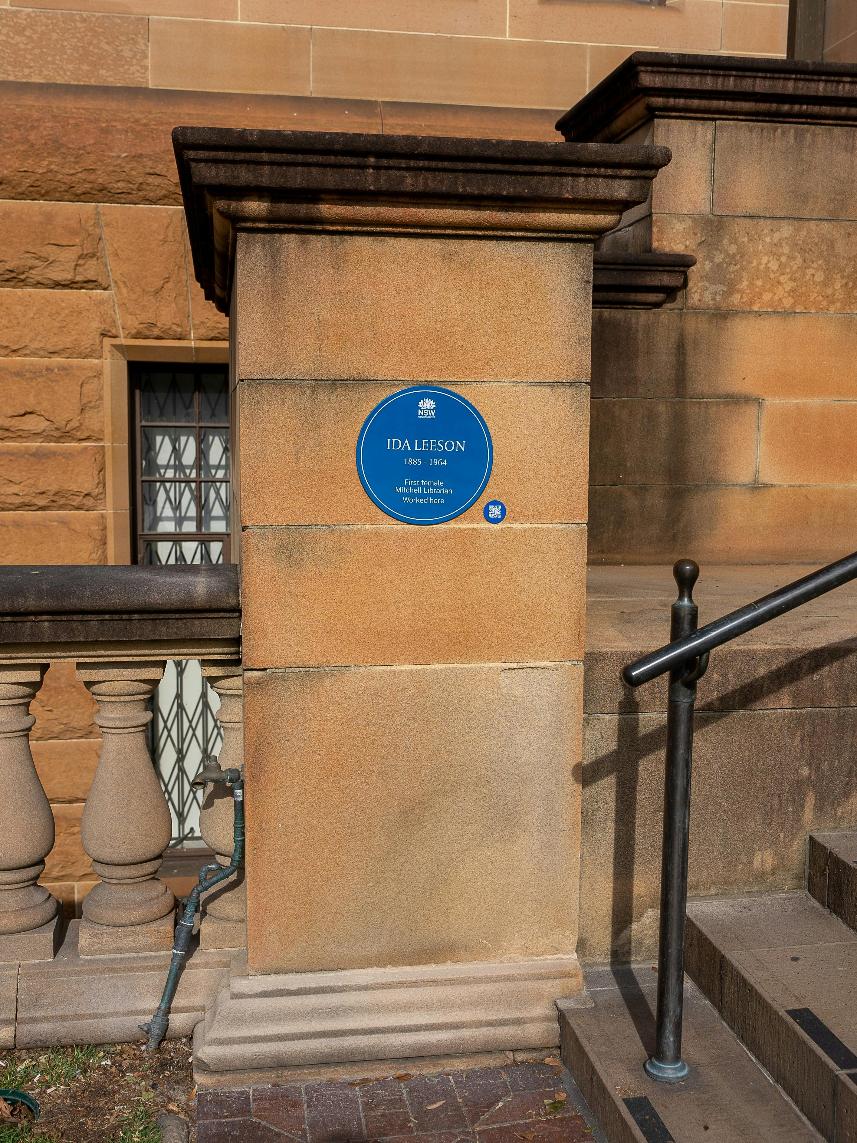 Blue plaque on sandstone pillar next to stairs