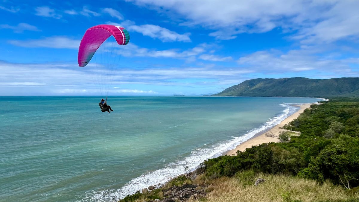 Paragliding by the sea, beach and rainforest