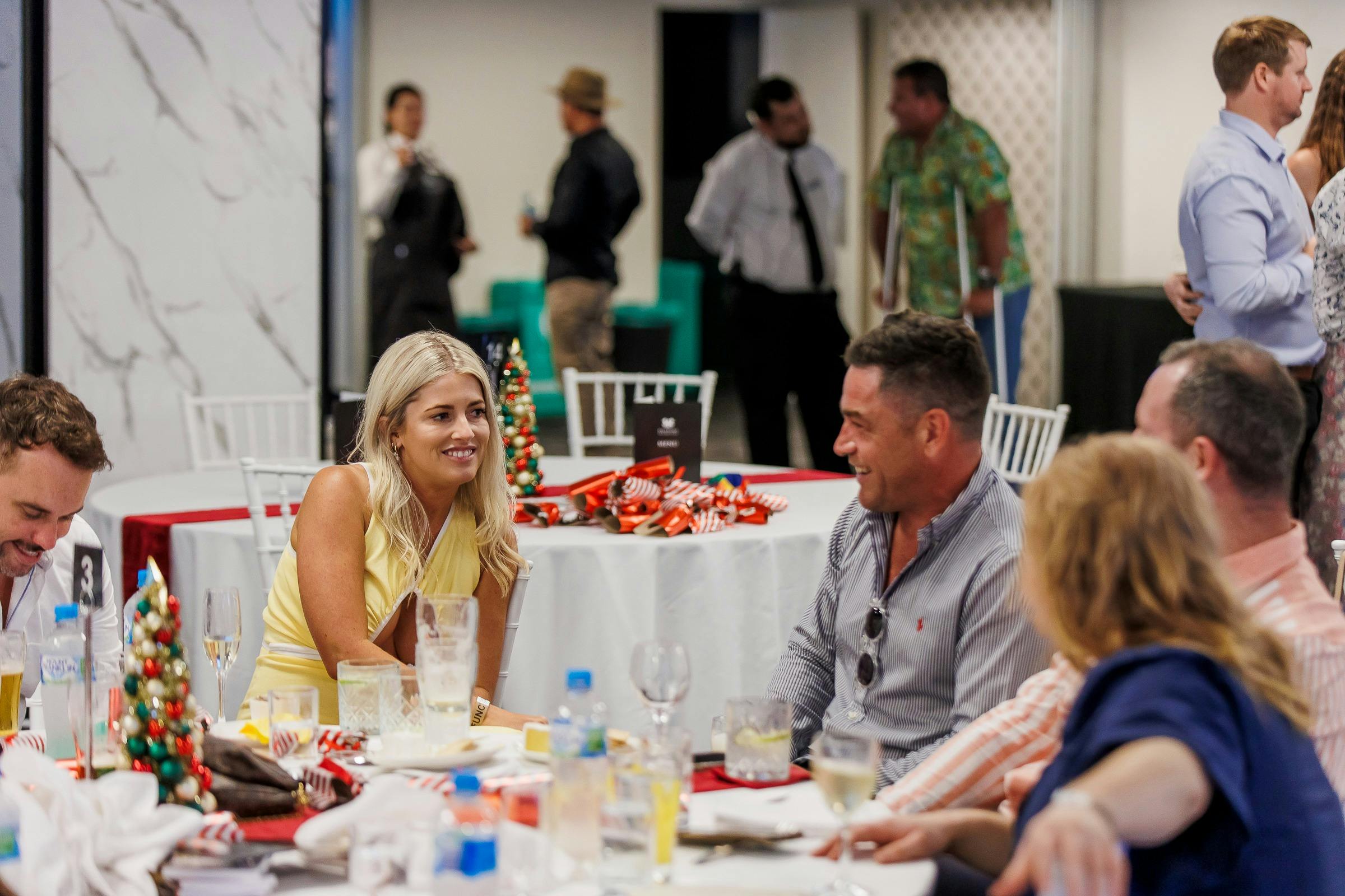 People laughing sitting at a table with Christmas decorations