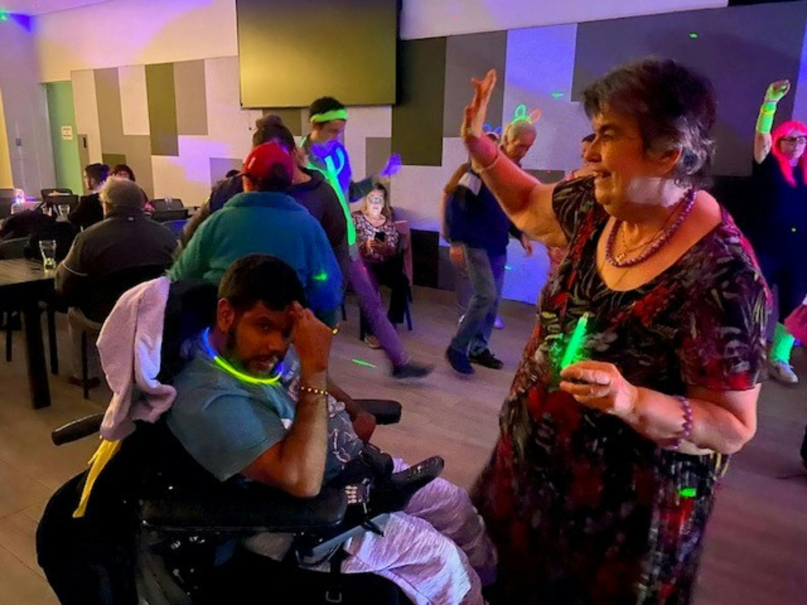 People enjoying an inclusive disco event in a function room.
