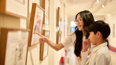Children view artwork in gallery.