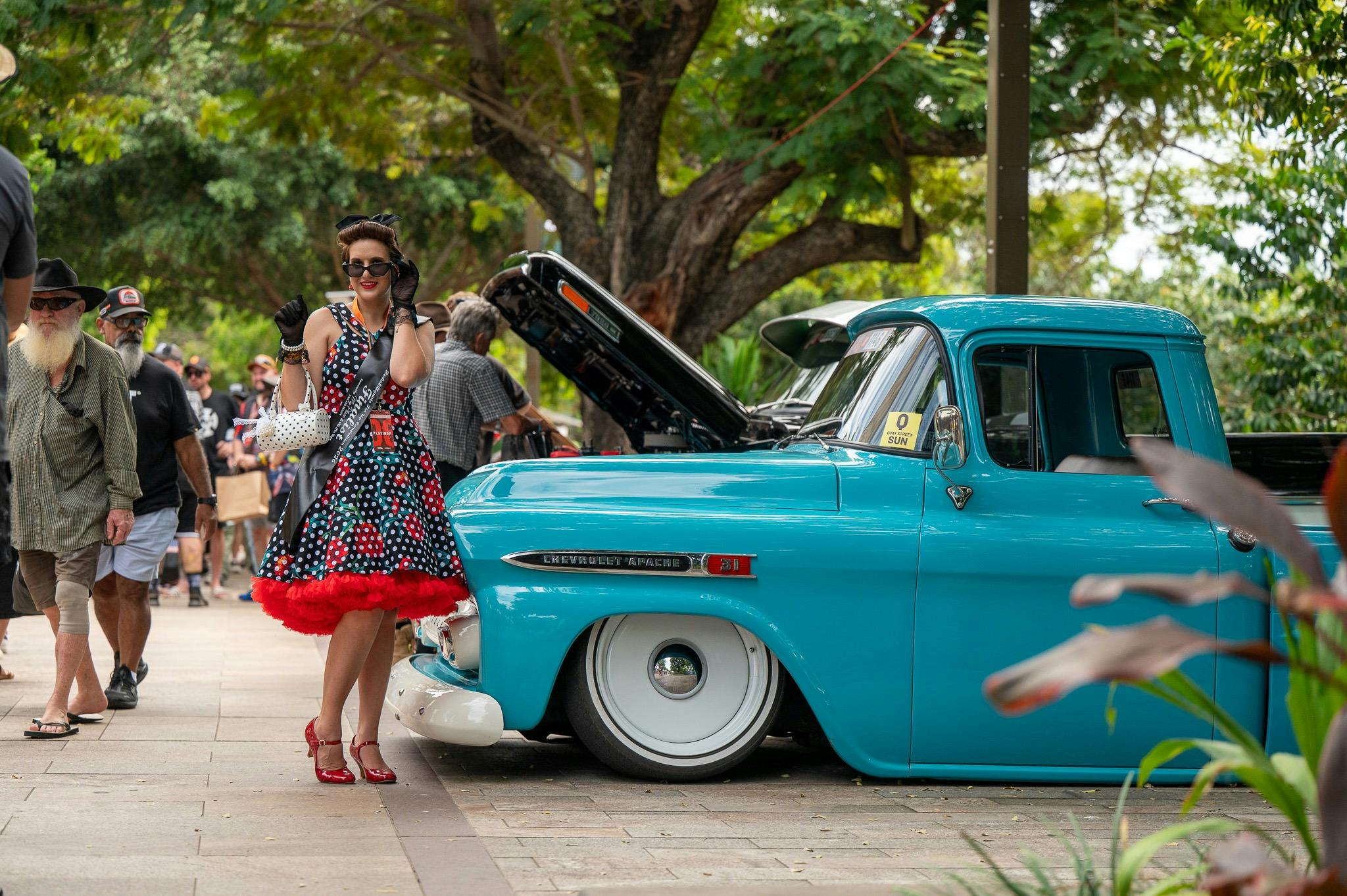 Rockabilly and pin-up girl beside a classic car at Rockynats.