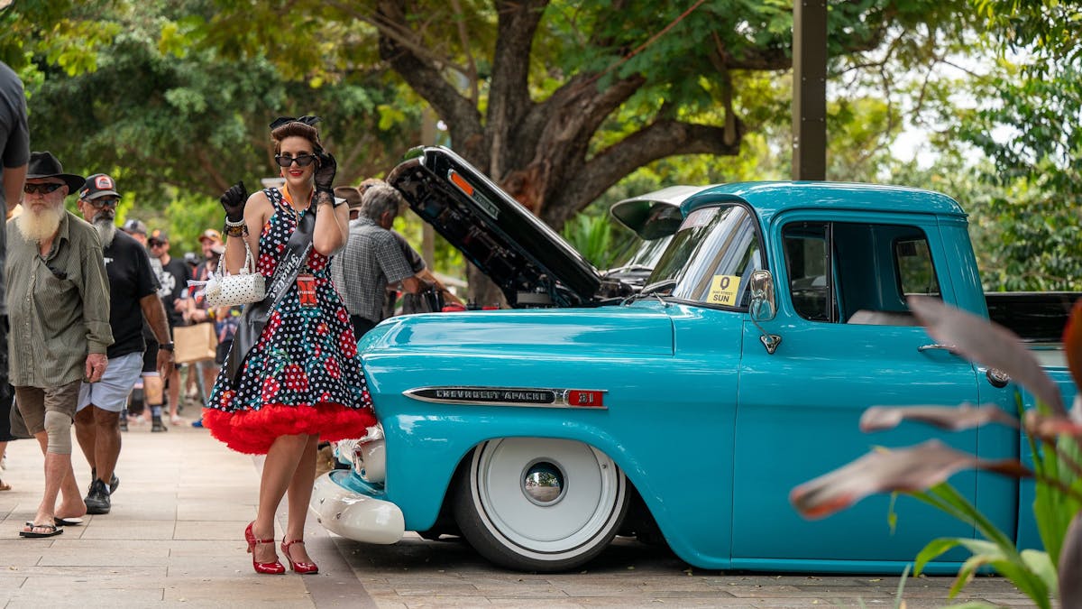 Rockabilly and pin-up girl beside a classic car at Rockynats.