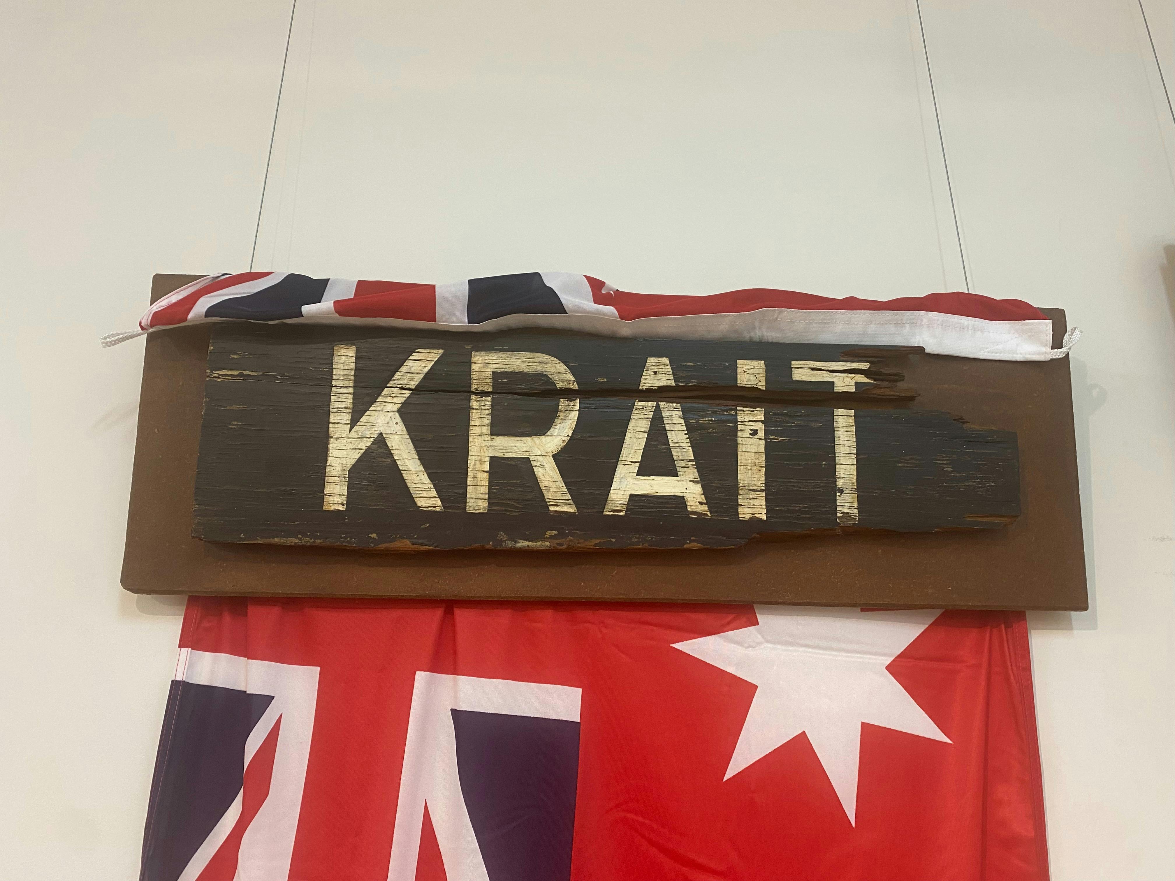 A wooden sign with KRAIT, displayed with the red Australian flag
