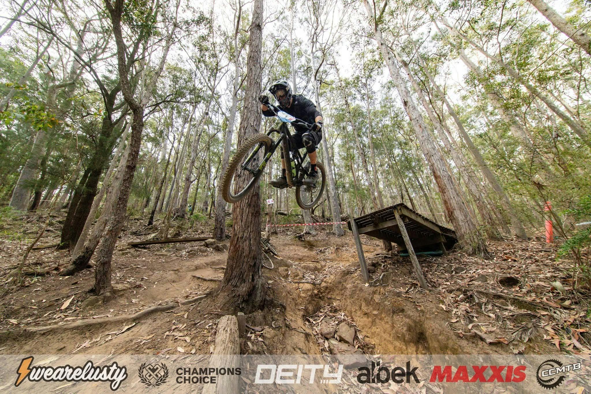 Mountain biker mid-air over a gap jump at Ourimbah Bike Park, NSW Central Coast