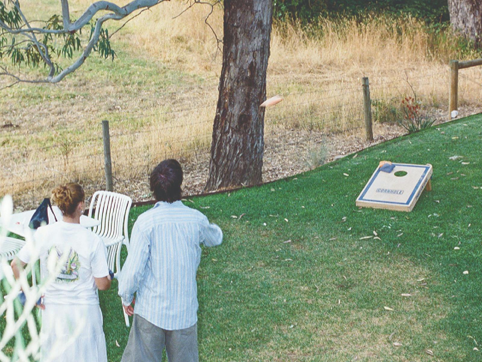 Two people playing corn hole on the lawns at Ambleside