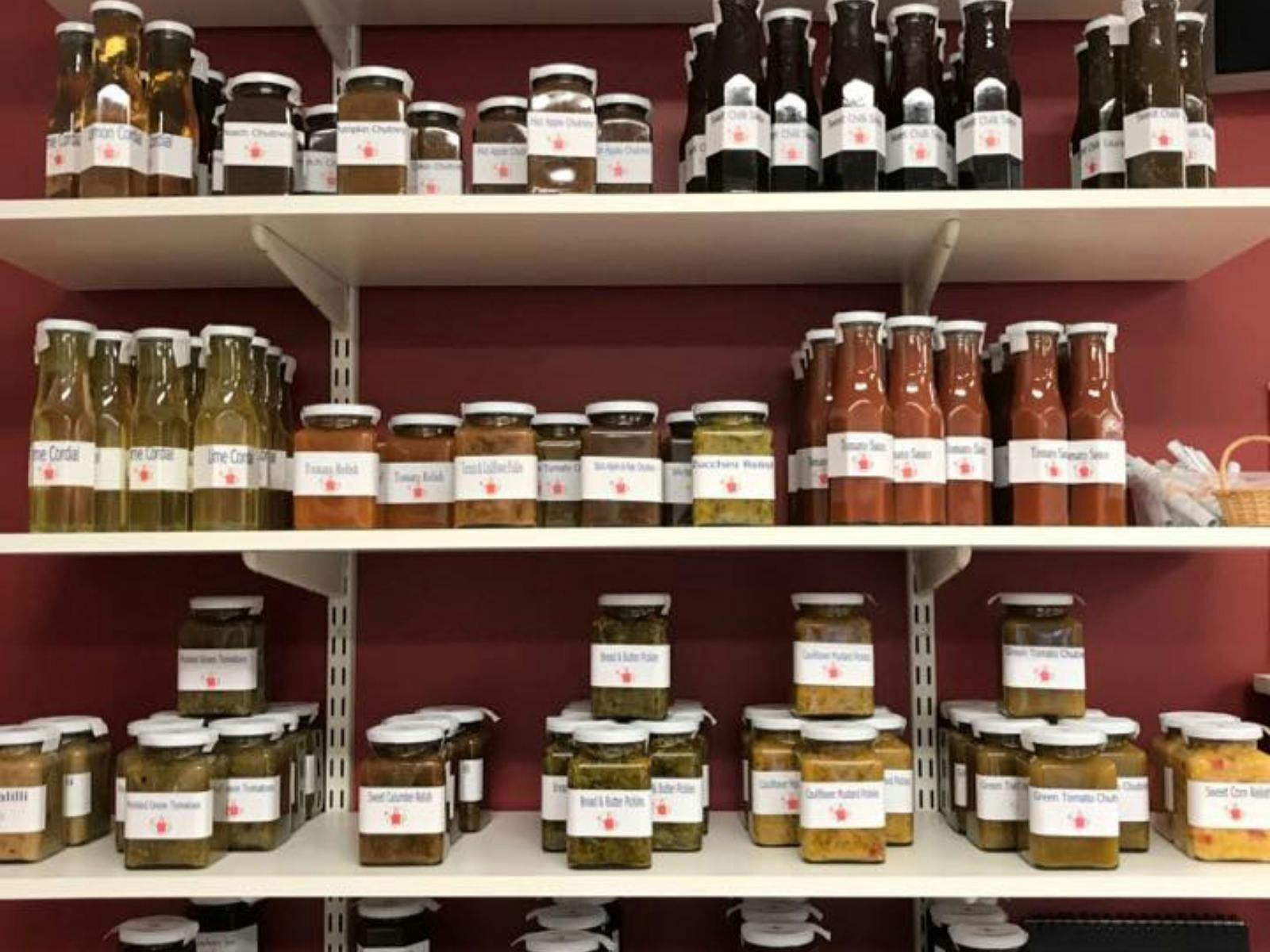 Jars and bottles of preserves on white shelves