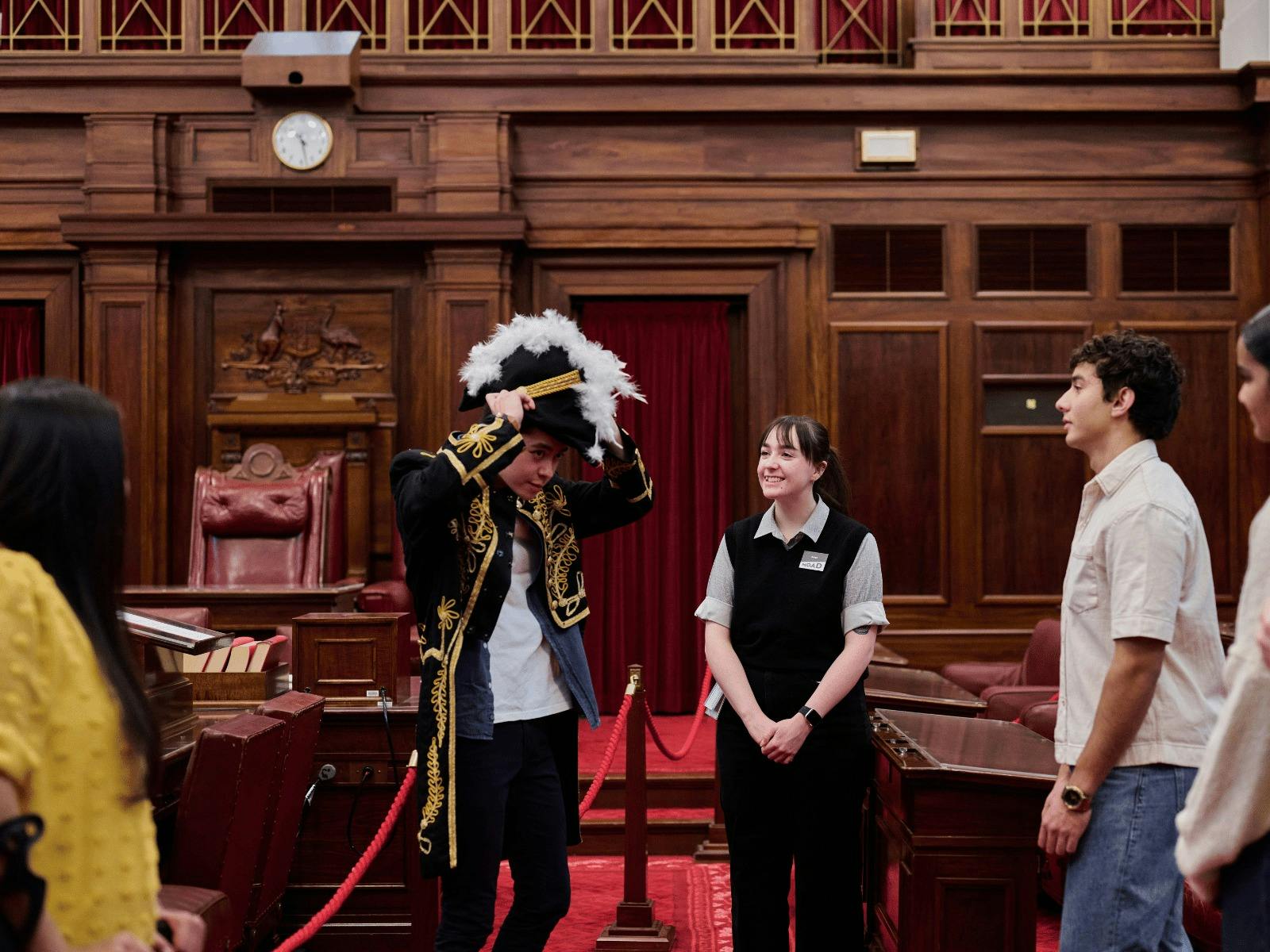 MoAD Experience Officer with group of people in the Senate Chamber