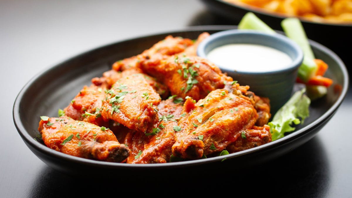A plate of chicken wings with ranch dressing