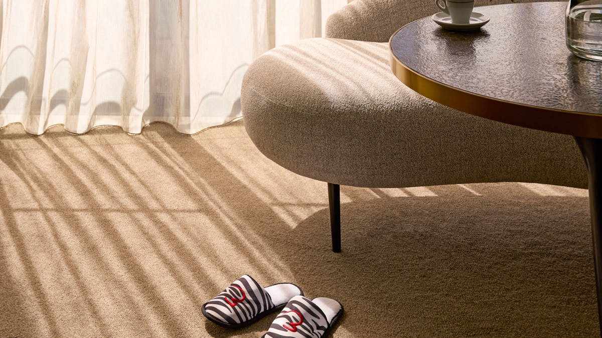 Soft morning light over a lounge chair, coffee cup and zebra-pattern slippers
