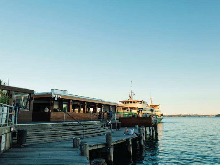 Sun setting over Hugos Manly at Manly Wharf on Sydney's northern beaches