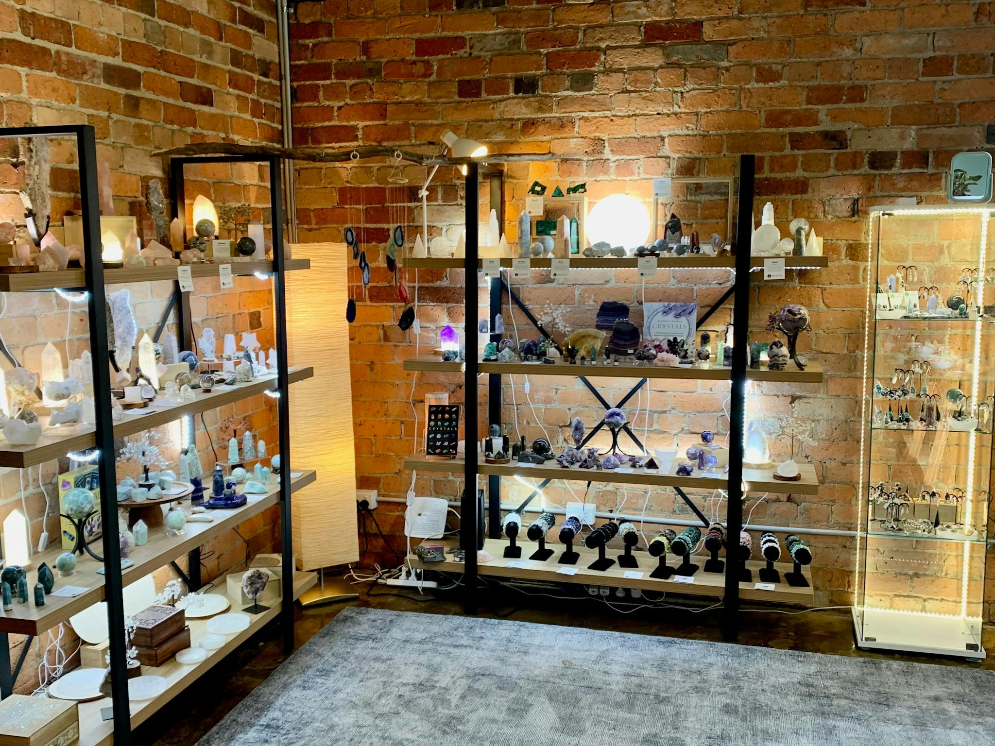 Shelving displaying crystals, lamps and jewellery.