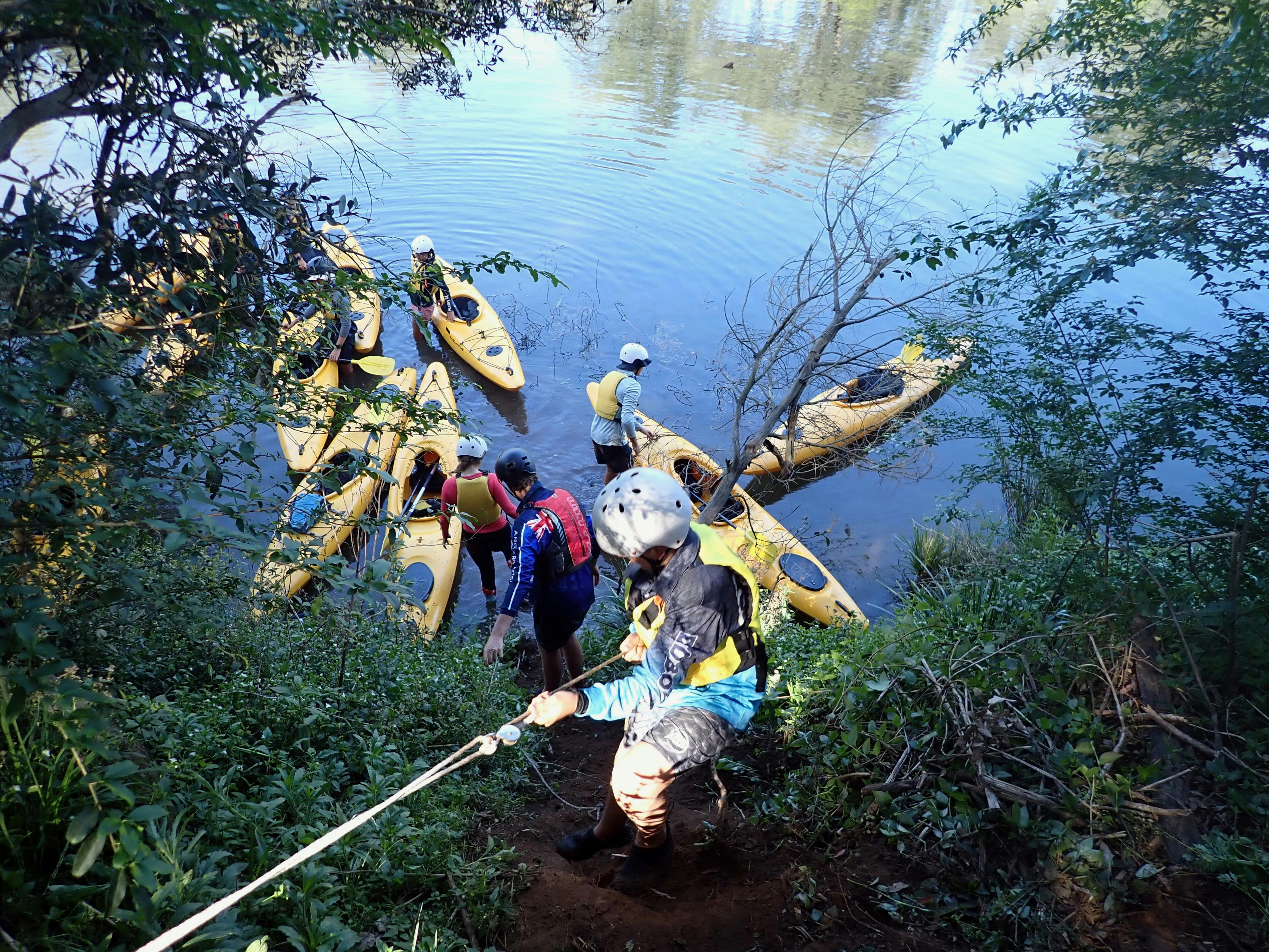 Kayaks are being lowered with a rope to the Nymboida River  below.