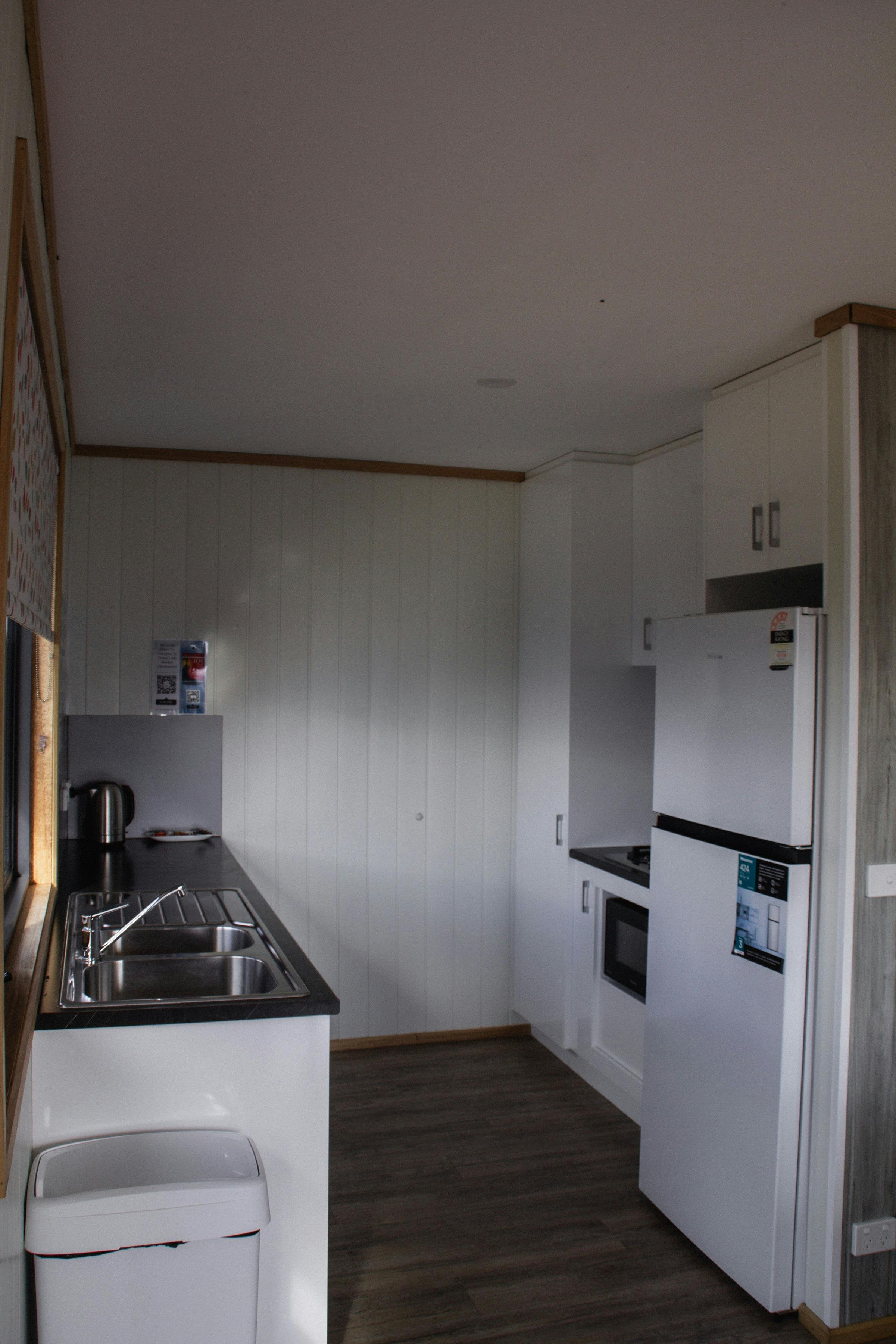 Fully equipped kitchen with modern appliances, white cabinetry and a sink