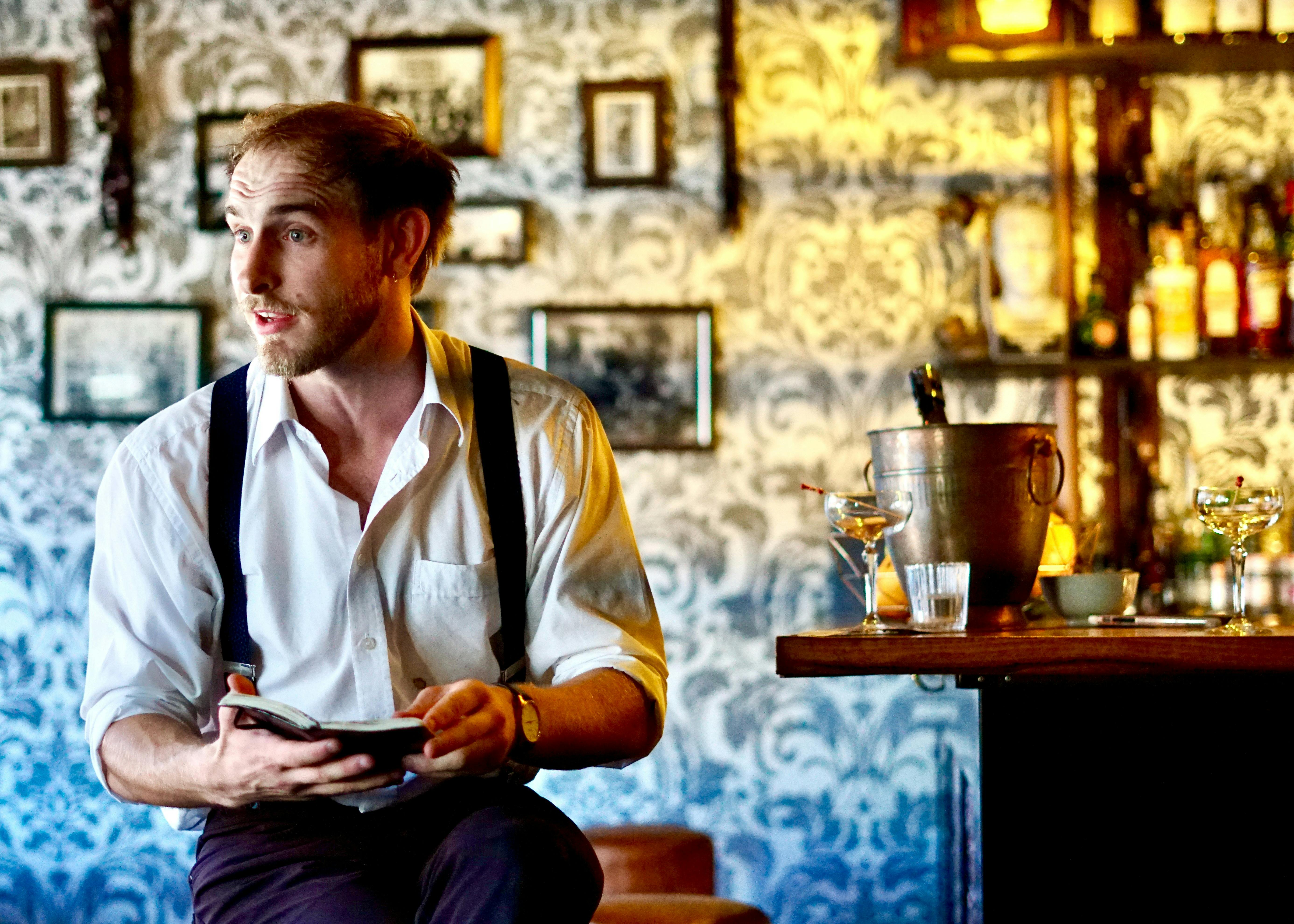 Performer acting as  a barman.