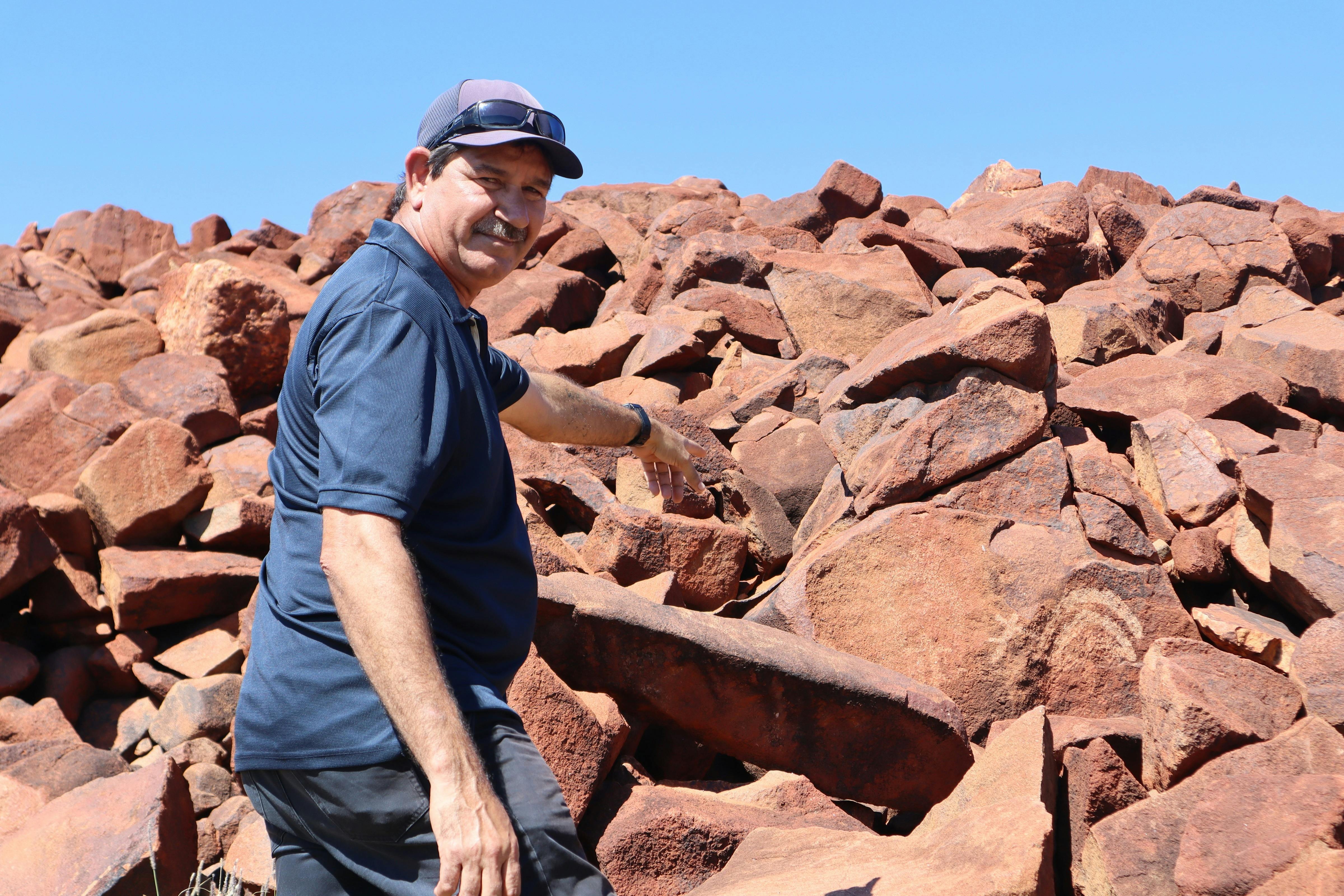 Visible rock art shows tribal symbols and is culturally approved for publication.