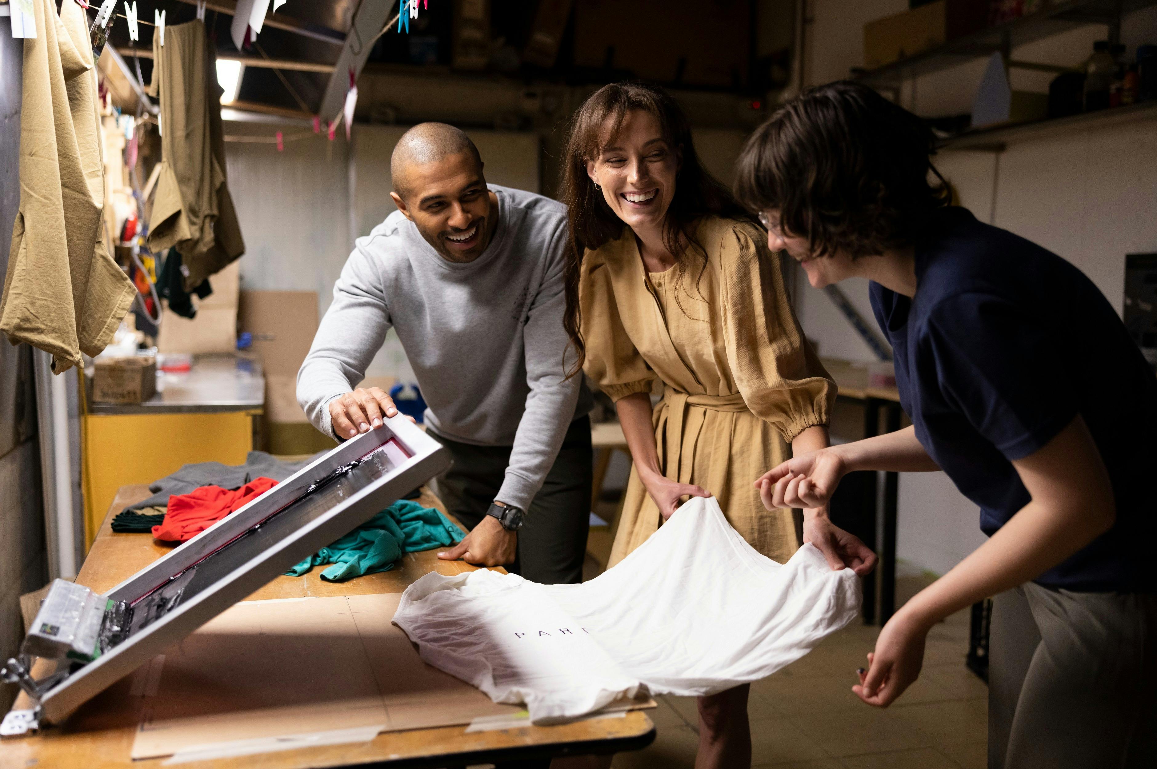 Couple working with a local artist to silk screen t-shirts at Pari art gallery, Parramatta