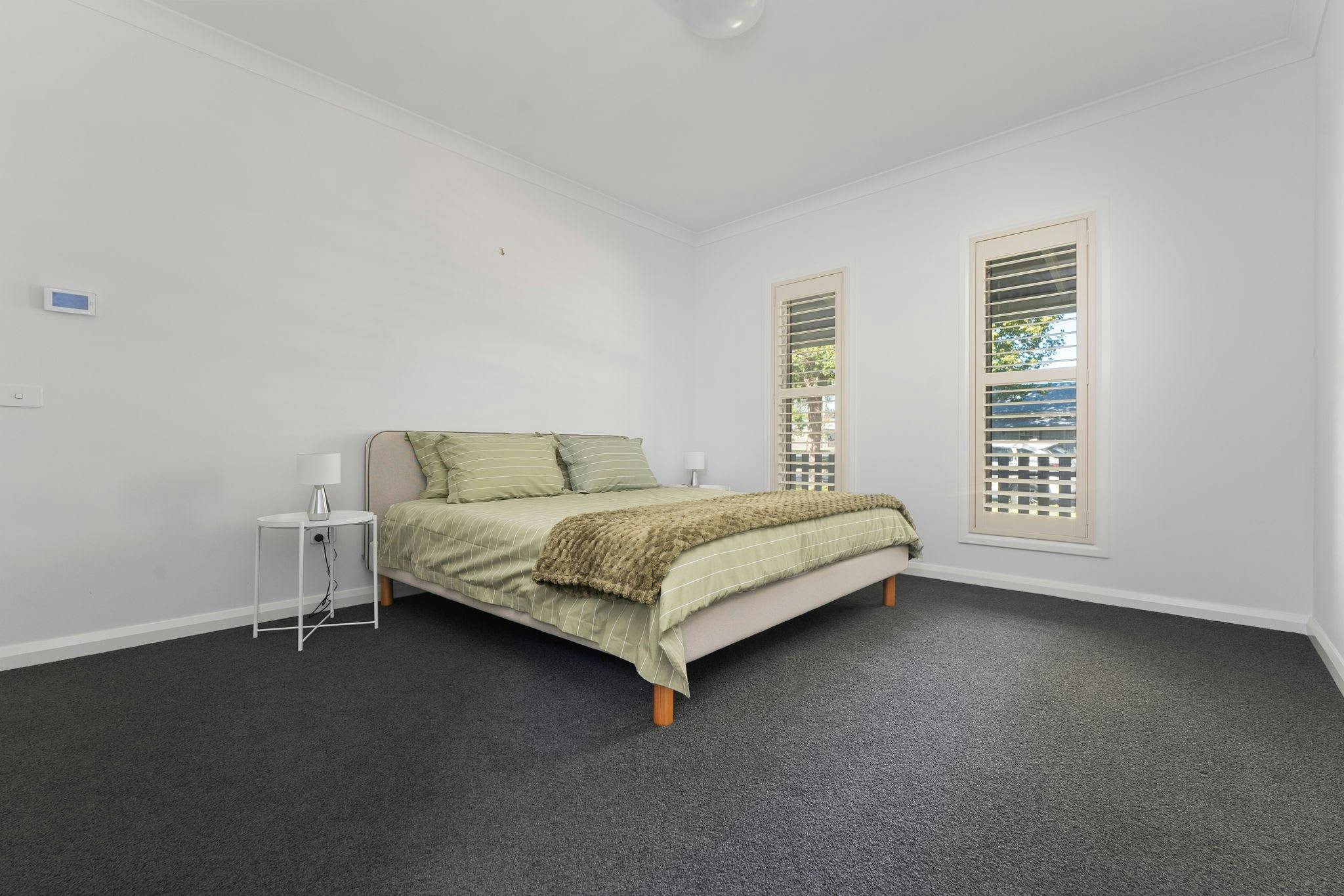 Bedroom with queen bed, green bedding and green throw