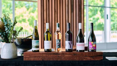 A line up of six Canberra wines on a wooden plinth