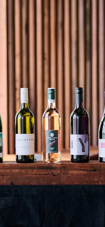 A line up of six Canberra wines on a wooden plinth