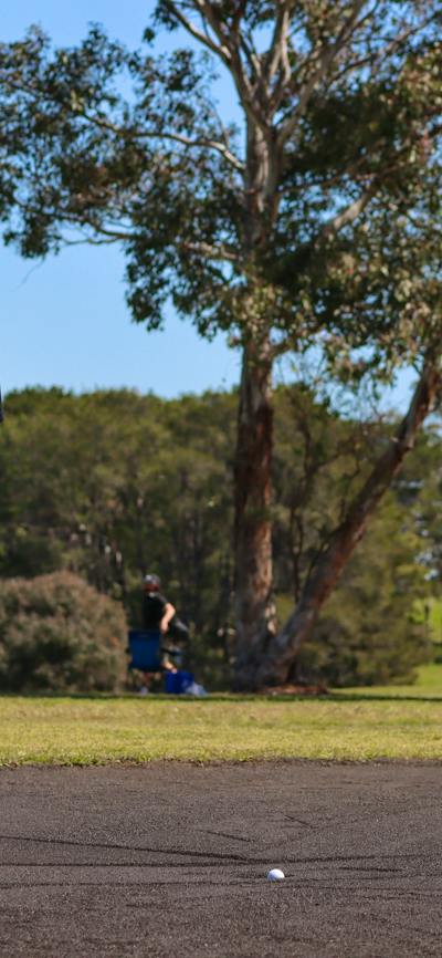 Male golfer making a putt on sand greens