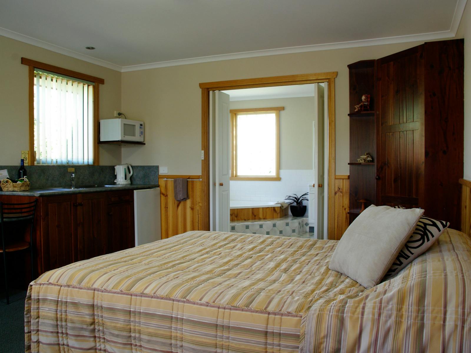 The spa room has a kitchenette with 1 Queen bed with a corner spa