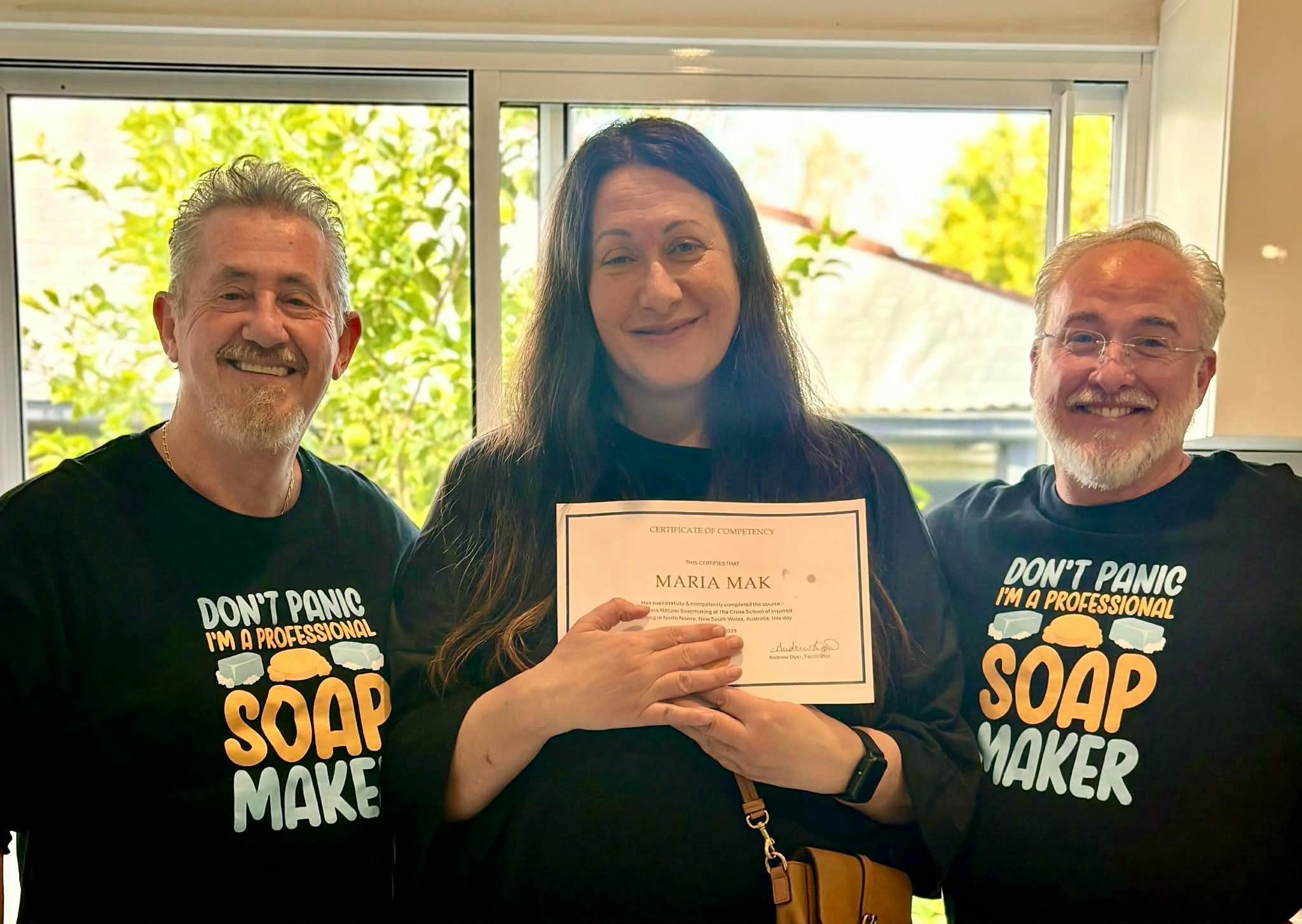 A student receiving her certificate of competency flanked by Crave School Teachers