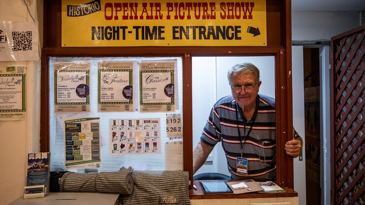 A volunteer peers through a service window selling tickets to the Vision Splendid Outback Film Fest.