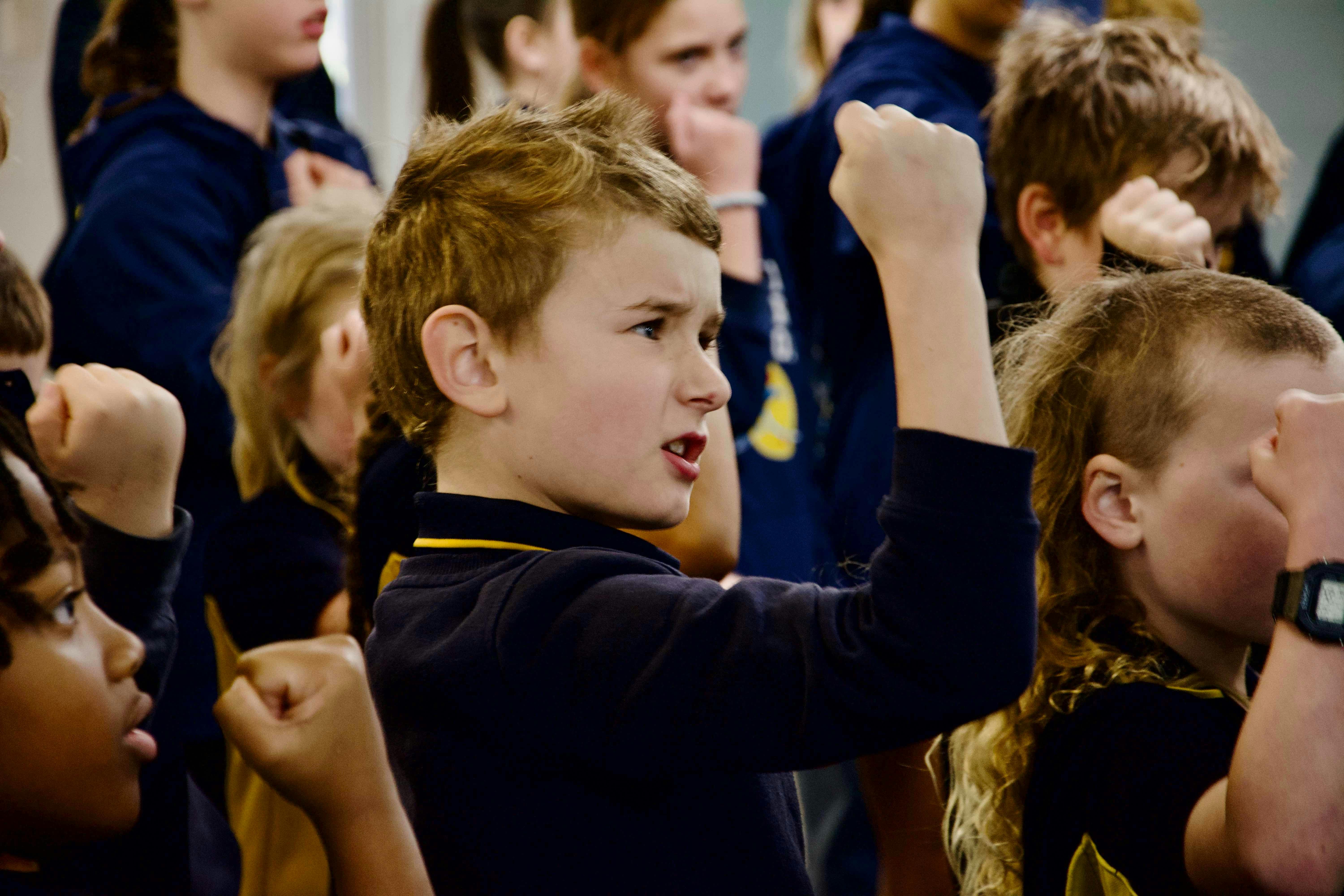 Boy performing actions in a choir setting.