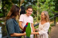 A wildlife keeper guiding two visitors to interact with two parrots at Wildlife Habitat Port Douglas